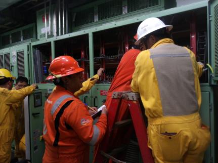 Cuadrilla técnica en sala eléctrica de instalación industrial costa afuera
